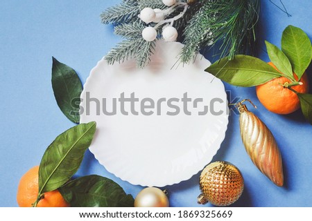 Christmas table setting in elegant style. White plate, mandarin oranges, New Year decoration. Festive mockup, banner