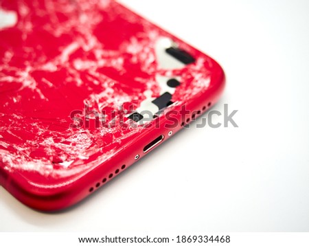 One damaged black smartphone with many scratches and crack on body isolated on white background