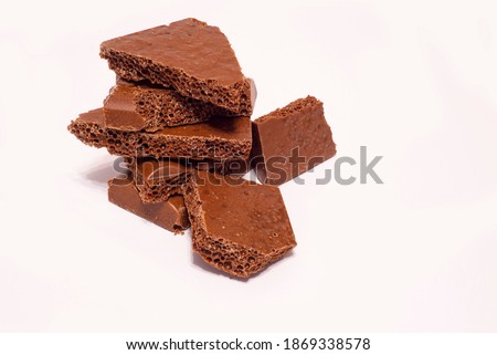 Milk chocolate on a white background. Porous bar of chocolate. Ingredient for cake and desserts. For recipes.