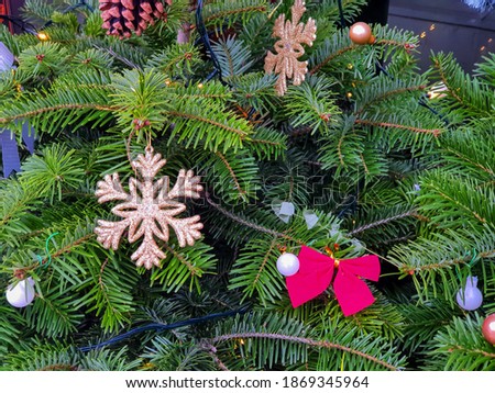 Street Christmas decoration with spruce branches, golden stars, red bows, small Christmas bubbles. Selected focus.