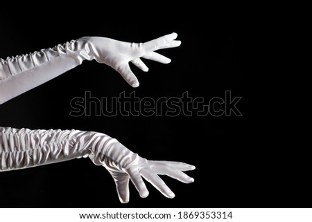 Hand gestures. Lady illusionist, beautiful hands in long white gloves make a spell. Shows and tricks and illusions, hands are drawn to the right side.