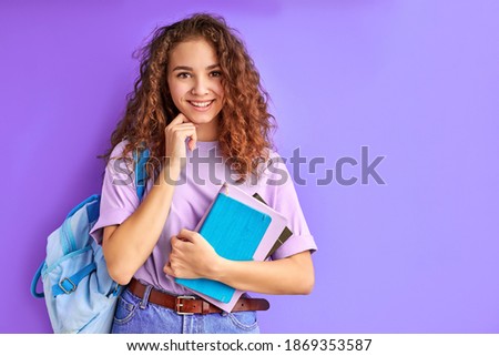 sweet caucasian friendly young student girl holding colorful exercise books, ready to study
