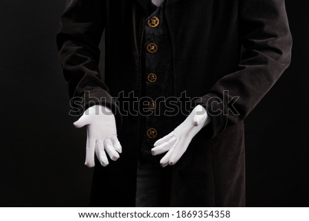 Hand gestures. Show something with your hands, open palms, announcement of the start of the show. Showman or magician illusionist in white gloves on a black background.