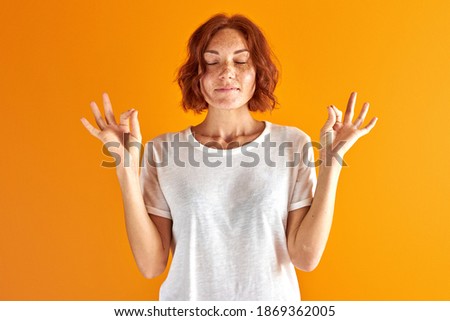 woman is meditating isolated in studio on orange background, keep calm. yoga concept