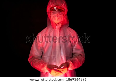 portrait of doctor male in medical suit posing isolated on black background, warning sign, warn people against the virus all over the world, covid-19 concept