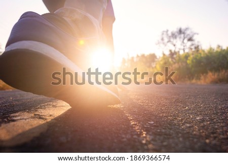 Close up shoe back side view of young man start running on the road. Jogging,happy,park,out door.Photo concept relaxing and lifestyle background.
