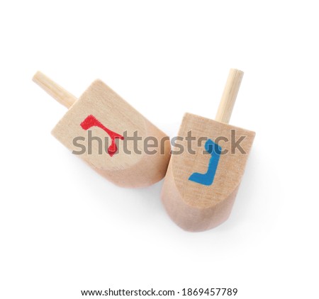 Wooden Hanukkah traditional dreidels with letters Gimel and Nun on white background, top view