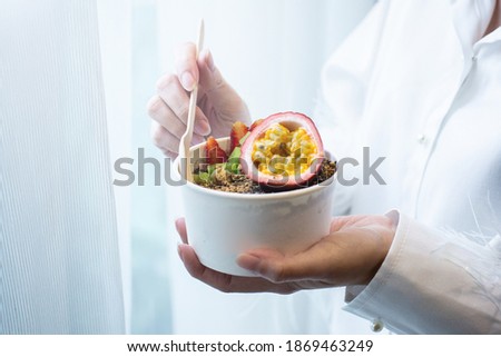 Hand holding Fruit plate with granola. healthy breakfast.
