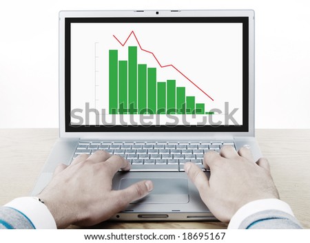 financial crash. man hands on the keyboard of laptop with graph on the display