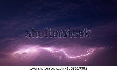 Bright Lightning On Purple Night Sky During Hunderstorm.