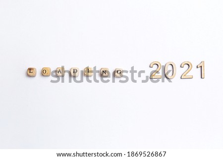 Loading 2021. Isolated on white background wooden cubes with letters Loading and wooden numbers 2021. New year concept