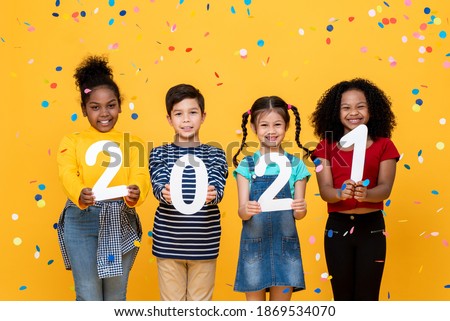 Cute smiling mixed race kids showing numbers 2021 celebrating new year isolated on yellow background Royalty-Free Stock Photo #1869534070
