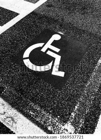 Road sign for the disabled on the asphalt of the road surface.