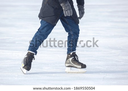 man actively skates on an ice rink.