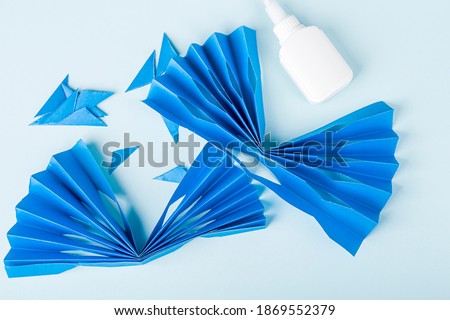 Concept of DIY and kid's creativity, origami. Step by step instruction: how to make paper snowflake. Step 4 We glue sheets of paper together. Children's New year craft