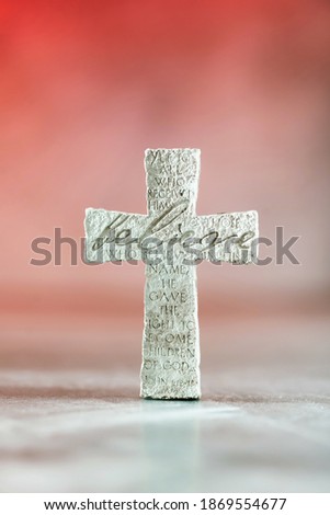 Stone cross with inscription Believe on red background, Copy space. Christian backdrop. Biblical faith, gospel, salvation concept. Banner.
