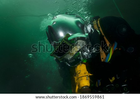 professional diver working underwater with pneumatic tools Royalty-Free Stock Photo #1869559861
