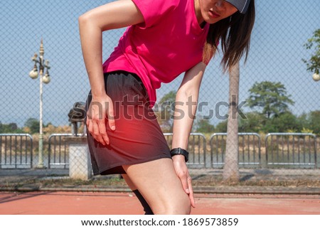 Runner woman having suffering from waist pain after doing hard workout. Muscle strain is often the cause of waist pain from heavy lifting or vigorous exercise. Royalty-Free Stock Photo #1869573859