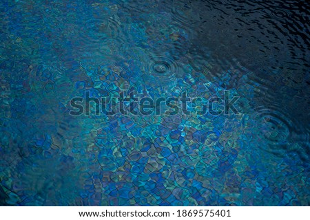 Circle water ripple wave surface background. Rain drop on swimming pool, blue background. High quality photo