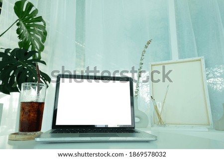 Cropped shot of simple workspace with blank screen laptop.