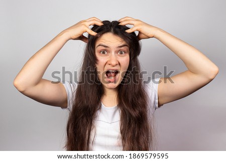 The girl grabbed her head and screams for problems with dandruff and hair loss. Scalp fungus, stress and baldness, skin itching