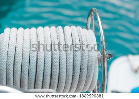 Harbour lines in coul, light grey nautical ropes on sea water  background