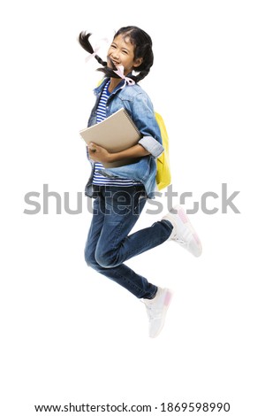 Asian schoolgirl and her stationery jumping with smile face on a white background.