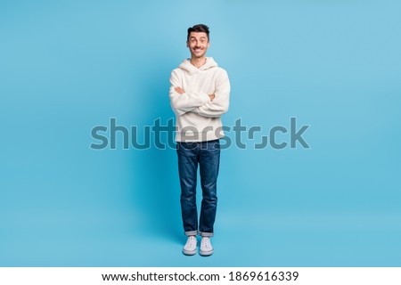 Photo portrait full body view of guy with folded arms wearing woolen hoodie isolated on pastel blue colored background