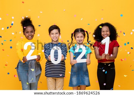 Cute smiling diverse kids showing numbers 2021 celebrating new year isolated on yellow background Royalty-Free Stock Photo #1869624526