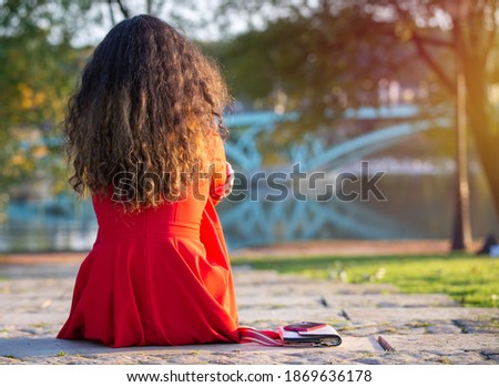 A woman waits for her lover alone on the aisle in the park in the evening to discuss common problems. The idea of waiting alone in hope. Copy space