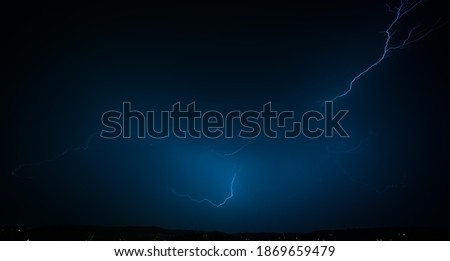 Lightning strike on a dark blue sky. bolt of light cutting night sky