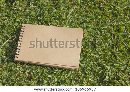 notebook for sketching lying on green grass