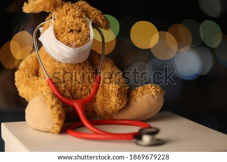 Soft toy dog sits in protective medical mask and stethoscope. Coronovirus pandemic and quarantine concept