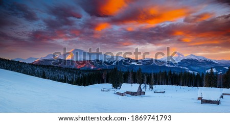 Snow-capped mountain huts in the frosty evening. Location place Carpathian mountains, Ukraine, Europe. Christmas holiday concept. Vibrant photo wallpaper. Happy New Year! Discover the beauty of earth.