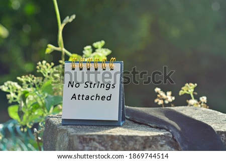 No strings attached text written on white note with green blurred background of hanging bridge - Powerful words