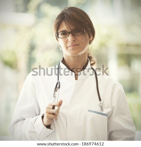 Friendly female doctor smiling to you next to a clinic