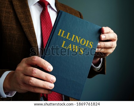 State Illinois law concept. A man in a suit is holding a book.