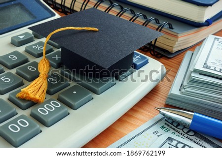 Student loan concept. Graduation cap on the calculator. Royalty-Free Stock Photo #1869762199