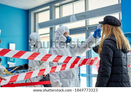 disinfectants use an Infrared thermometer equipment to check the temperature on the forehead, screen the patients addicted to Covid before entering the building