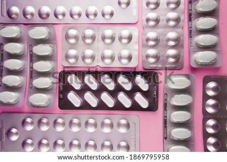 Pills in a blister pack. 
pills in packaging pink background