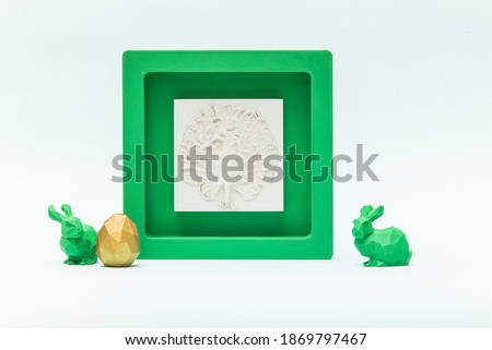 Trendy Easter low poly decor - botanical bas-relief cabbage leaf, golden egg and green bunnies of geometric style. Happy Easter greeting card. 3D plaster decor. Modern and luxury interior of room.