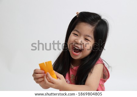 The Asian girl using scissor to cut the paper.