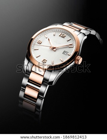 Men's pink and white gold luxury watch, isolated on black. Studio shot.