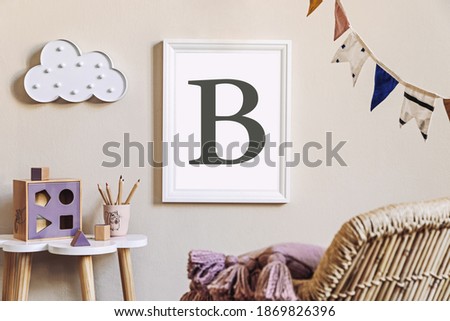 Stylish scandinavian nursery interior with mock up photo frame, toy, design furniture, pillows and accessories. Beautiful decoration on the beige background wall. Home decor for children room.