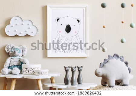 Stylish scandinavian nursery interior with mock up photo frame, toy, design furniture, pillows and accessories. Beautiful decoration on the beige background wall. Home decor for children room.