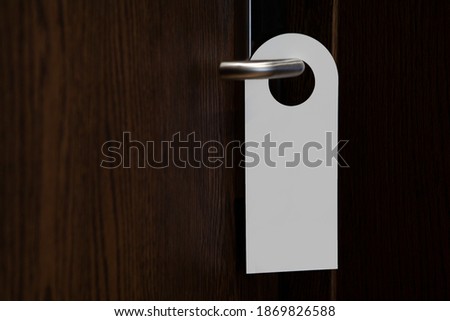 Door knob with blank doorhanger mock up. Empty white flyer mockup hang on door handle. Leaflet design. Dont disturb sign. Hotel room clear hanger. Do not disturbing signal. Royalty-Free Stock Photo #1869826588