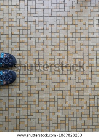 foot on vintage pattern tiles texture floor . comfortable footwear . top view