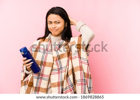 Young chinese woman doing a camping isolated on pink background trying to listening a gossip.