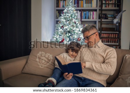 Dad and son are reading a book