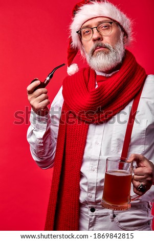 mature man in xmas outfit hat using smoking pipe, naughty santa smokes a cigarette New Years holiday Bad Santa